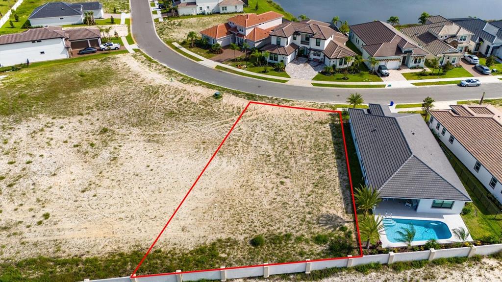 An aerial view shows a vacant residential lot outlined in red next to a house — 74 DEL PALMA DRIVE, PALM COAST, FL