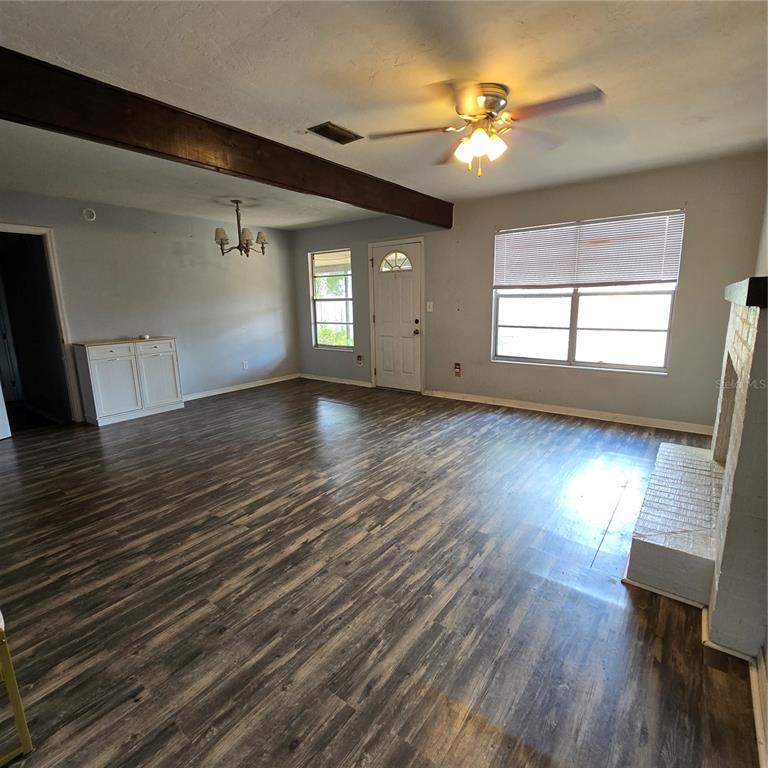 A dining room features a light wood table, six chairs, a rug, and a large mirror — 701 NW 24TH AVENUE, GAINESVILLE, FL
