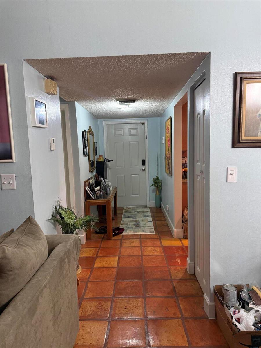 An entryway with terracotta tile flooring leads to a white front door — 6008 NW 1st Street, Margate FL 33063, MARGATE, FL