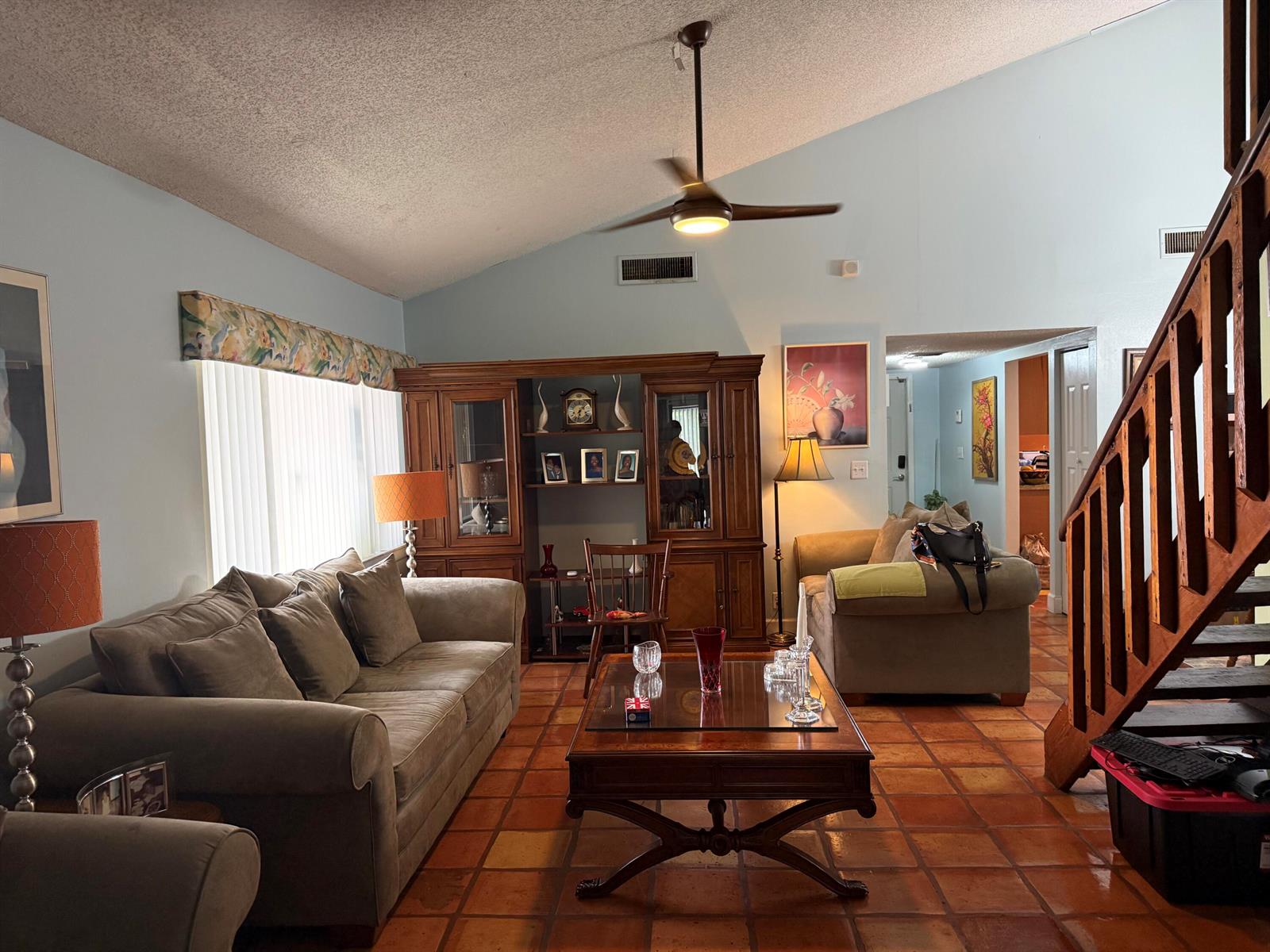 A living room features a vaulted ceiling, tile flooring, a wooden staircase, and a hutch — 6008 NW 1st Street, Margate FL 33063, MARGATE, FL