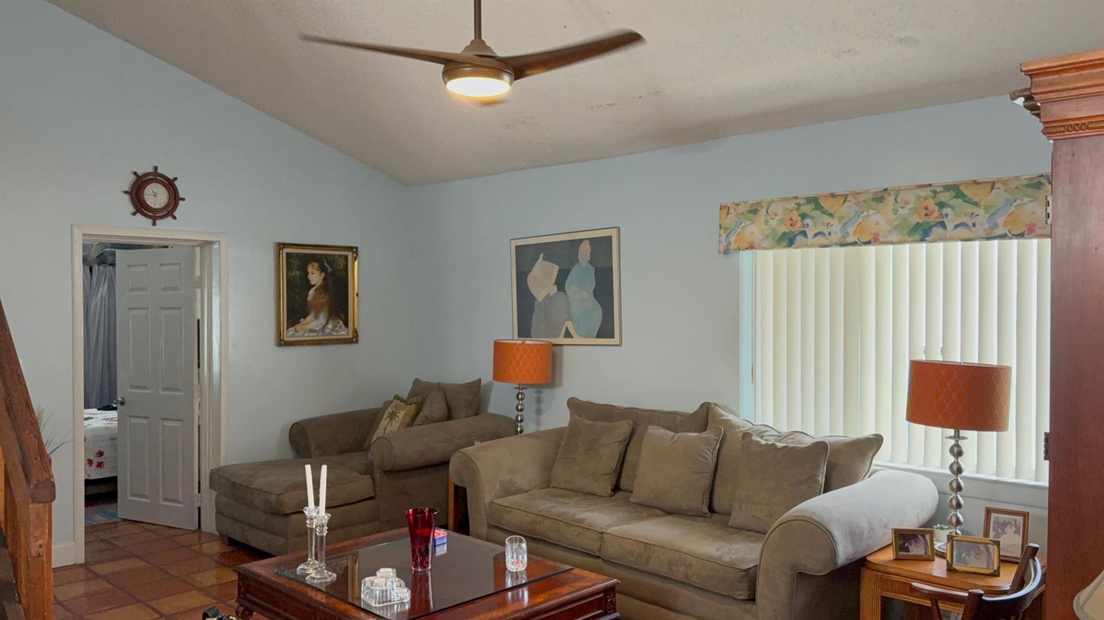 A living room with light blue walls, a ceiling fan, brown sofas, and a coffee table — 6008 NW 1st Street, Margate FL 33063, MARGATE, FL