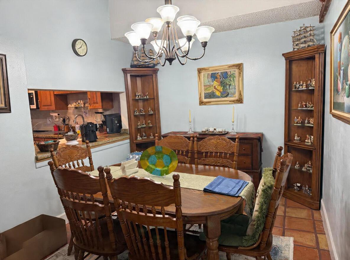 A dining room features a wooden table and chairs, two corner cabinets, and a chandelier — 6008 NW 1st Street, Margate FL 33063, MARGATE, FL