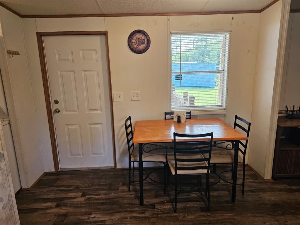 A dining area features a wooden table with four chairs, a window, and a door — 9050 SE 196TH TERRACE, OCKLAWAHA, FL