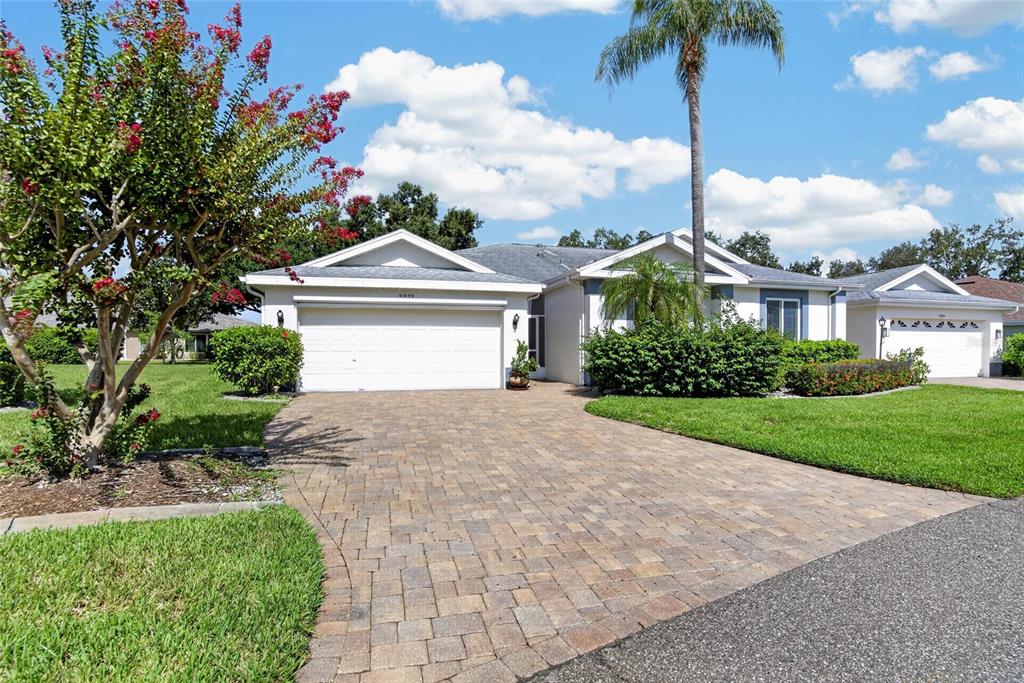 A single-story house with a paved driveway, a two-car garage, and a palm tree — 2222 MAYFIELD PALMS LANE UNIT 322, SUN CITY CENTER, FL
