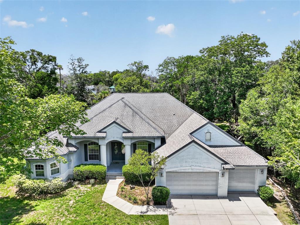 An aerial view of a single-story suburban house with a gray roof and attached garage — 720 NORTHWEST SNUG HARBOR ROAD, CRYSTAL RIVER, FL