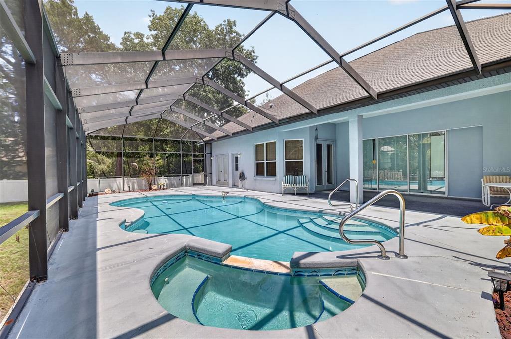 A screened-in patio features a swimming pool with an attached spa and concrete decking — 720 NORTHWEST SNUG HARBOR ROAD, CRYSTAL RIVER, FL