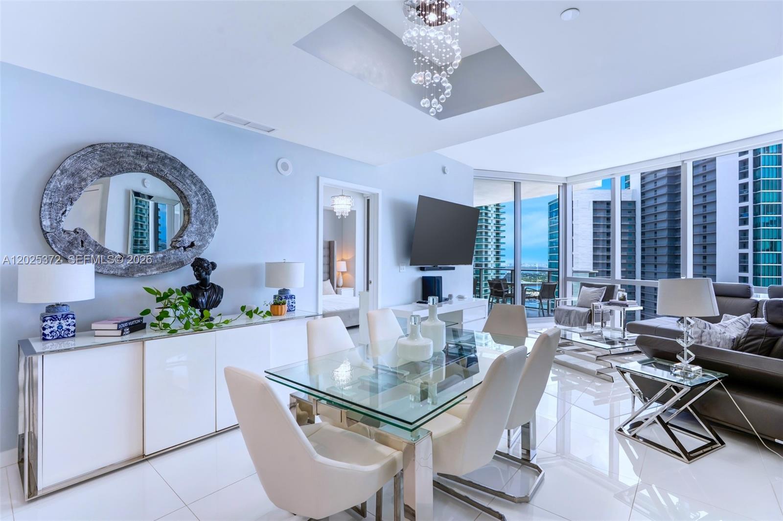A modern dining and living area features a glass table, white chairs, and city views — 851 NE 1st Ave # 3909, Miami FL 33132, MIAMI, FL