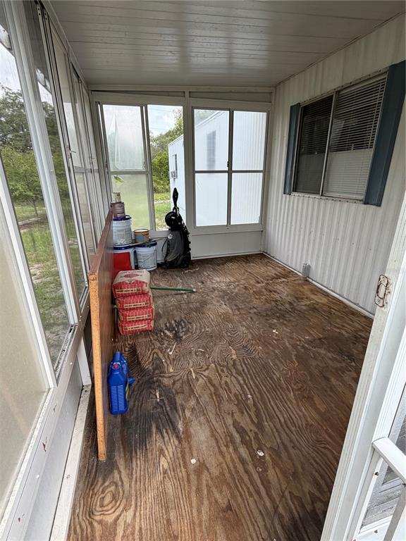 A sunroom with exposed plywood flooring, large windows, and a white paneled ceiling — 5270 W GLENBROOK STREET, HOMOSASSA, FL