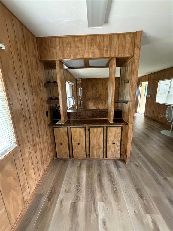 A room with wood-paneled walls features a built-in bar area with lower cabinets and shelving — 5270 W GLENBROOK STREET, HOMOSASSA, FL