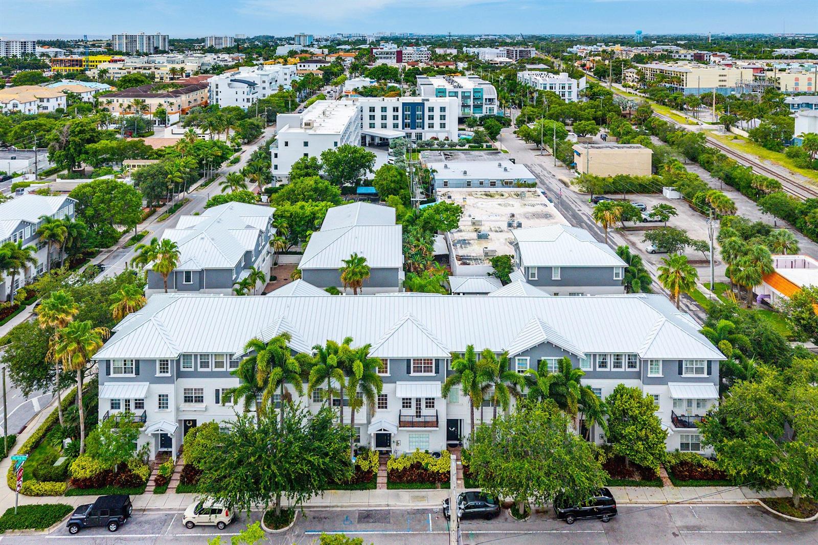 An aerial view of a multi-story apartment complex with a metal roof and palm trees — 290 NE 5th Avenue # 9, Delray Beach FL 33483, DELRAY BEACH, FL