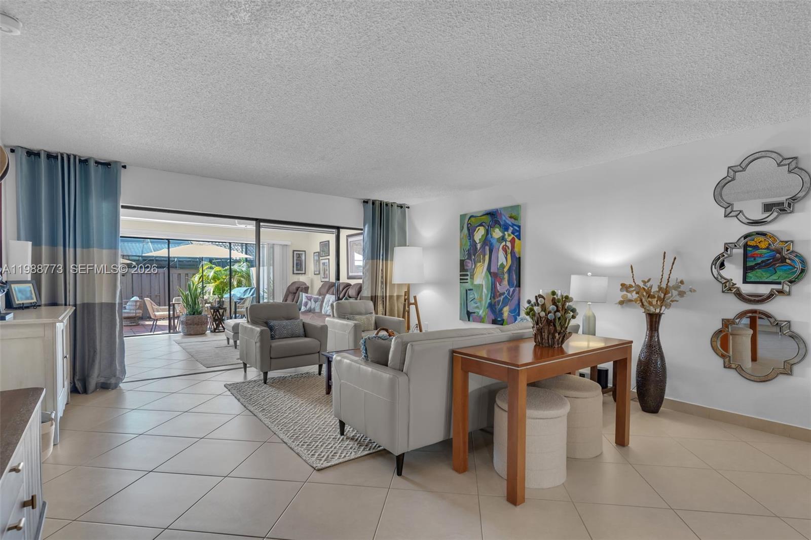 A living room features tile floors, a grey sofa, armchairs, and three decorative wall mirrors — 11378 SW 84th Ln, Miami FL 33173, MIAMI, FL