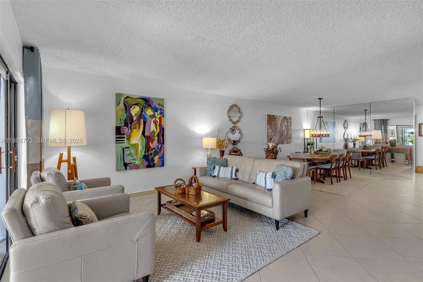 A living room with light-colored leather furniture, a patterned area rug, and a dining area — 11378 SW 84th Ln, Miami FL 33173, MIAMI, FL