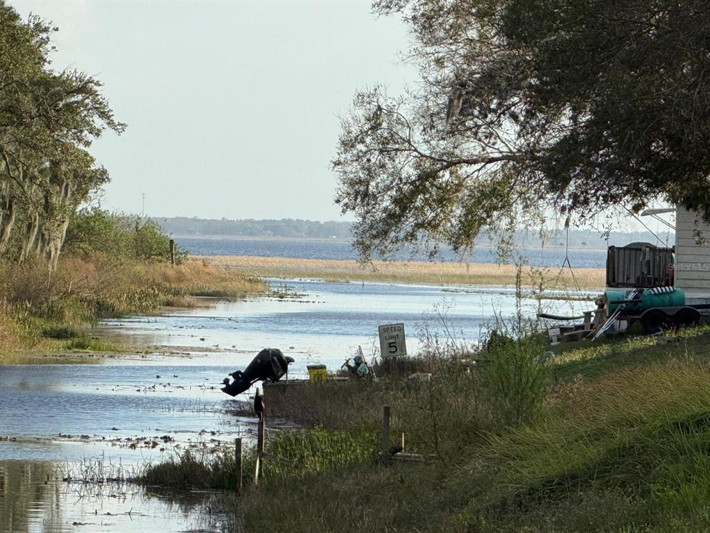 A view of a narrow canal leading to a large lake with a speed limit sign — CANAL COURT, LAKE WALES, FL