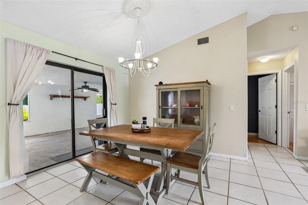 A dining room features a wooden table with a bench, chairs, and a hutch — 6805 LONGPOINTE WAY, TAMPA, FL