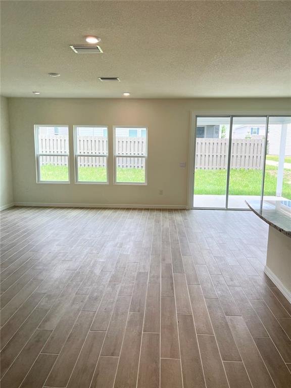 A living area features light-colored wood-look tile flooring, recessed lighting, and large sliding glass doors — 1336 NW 132ND CIRCLE, NEWBERRY, FL