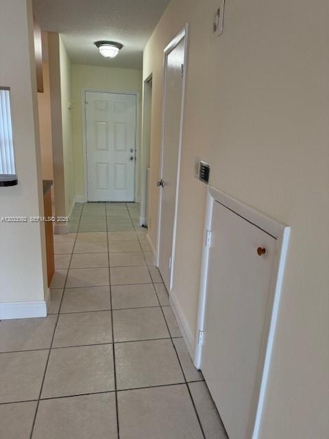 A hallway with light-colored tile flooring leads to a white front door — 2856 Cambridge Ln # 2856, Cooper City FL 33026, COOPER CITY, FL