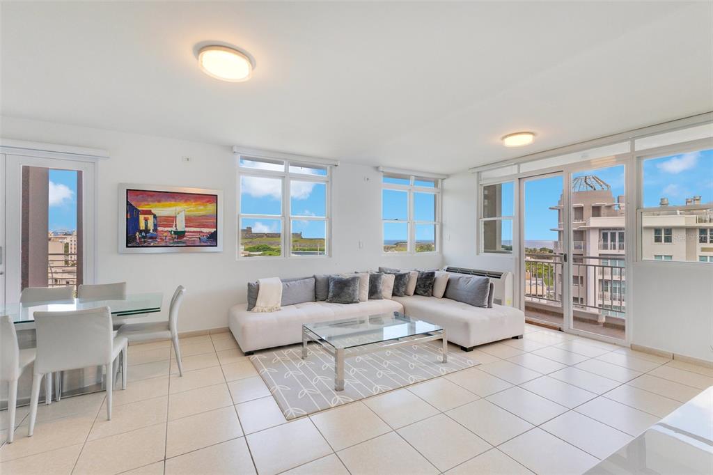 A living and dining area features a spiral staircase, tile floors, and large windows — 100 CALLE DEL MUELLE UNIT 21007, OLD SAN JUAN, PR