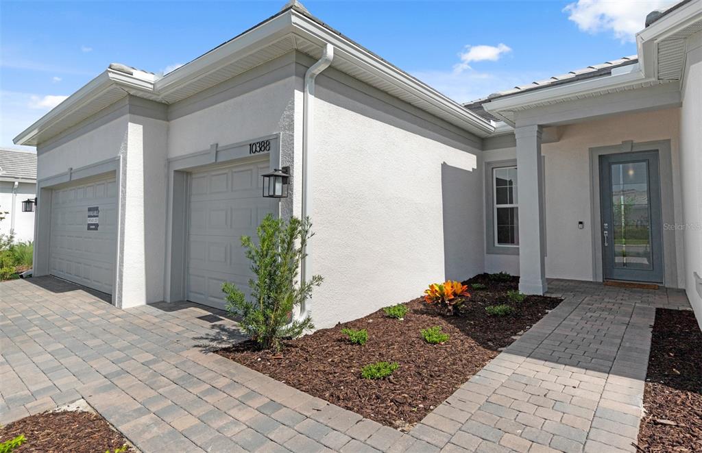 The exterior of a house features a paved driveway, a garage, and a front entrance — 26537 SANDY HILL CIRCLE, ENGLEWOOD, FL