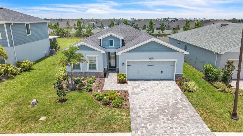 An aerial view of a single-story suburban house with a paved driveway and stone accents — 16239 S PORT HARBOR BOULEVARD, PORT CHARLOTTE, FL