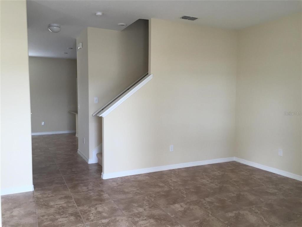 An interior view shows a tiled room with a staircase and a hallway entrance — 5618 WATER ROSE ROAD, WINTER GARDEN, FL