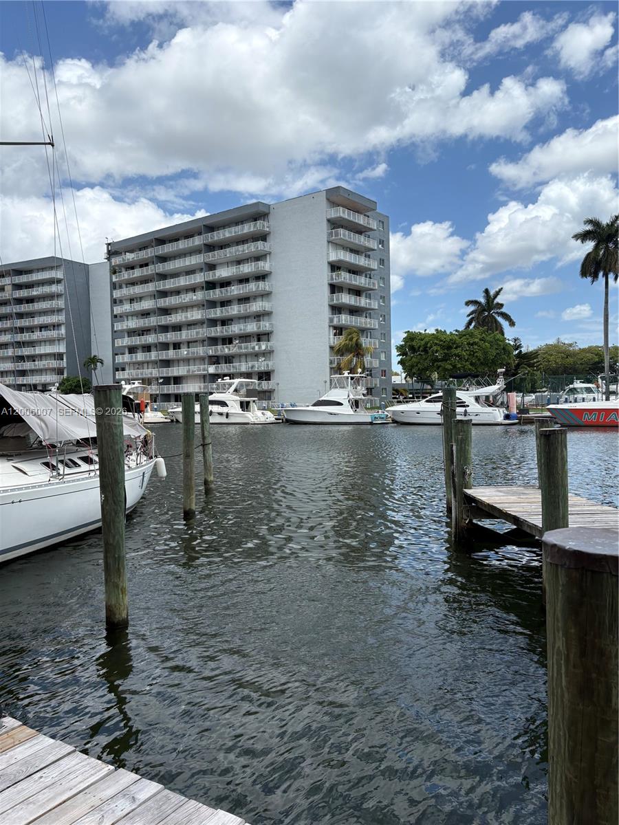 A view of a canal with several docked boats and a large apartment building behind — 2415 NW 16th St Rd #11, Miami FL 33125, MIAMI, FL