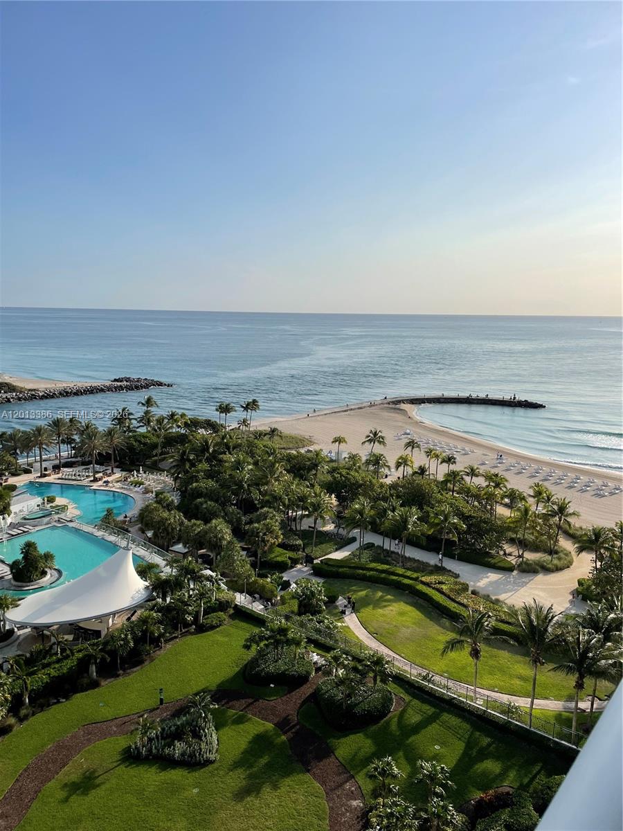 An elevated view shows a resort pool, lush landscaping, and a sandy beach with jetties — 10275 Collins Ave # 901, Bal Harbour FL 33154, BAL HARBOUR, FL