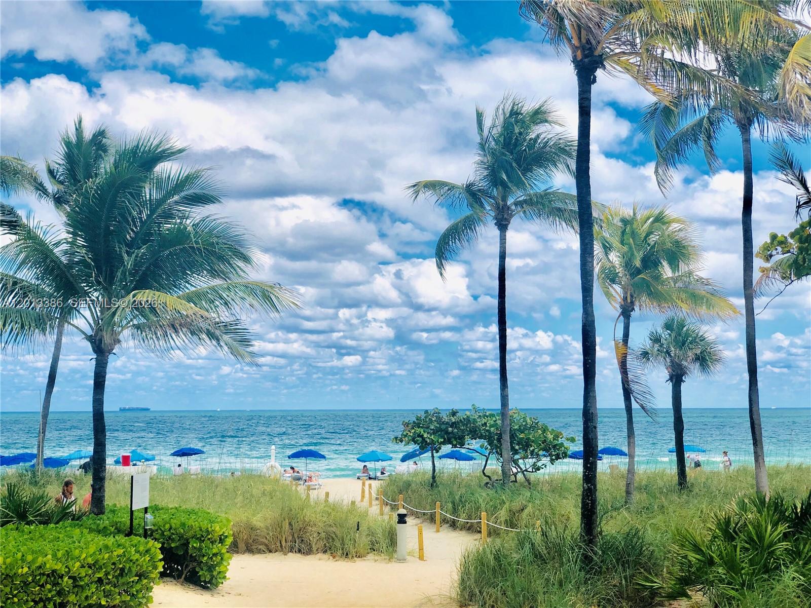 A sandy path leads through dunes and palm trees toward a blue ocean beach — 10275 Collins Ave # 901, Bal Harbour FL 33154, BAL HARBOUR, FL
