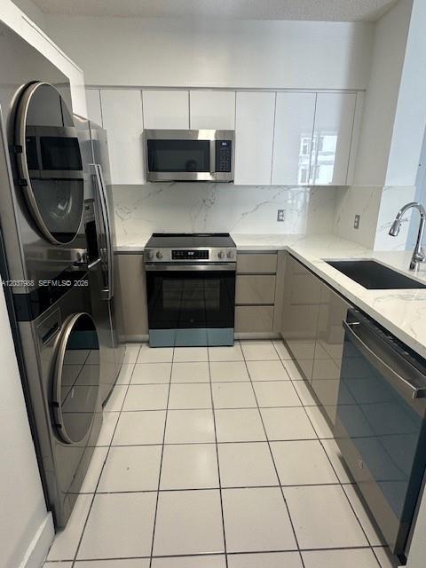A modern kitchen features stainless steel appliances, white cabinetry, and a marble-patterned backsplash — 5091 NW 7th St # 1008, Miami FL 33126, MIAMI, FL