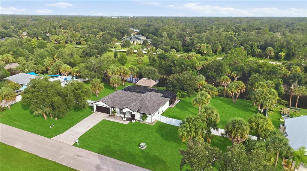 An aerial view of a single-story house with a pool enclosure and a large yard — 281 PEMBROKE DRIVE, PORT CHARLOTTE, FL