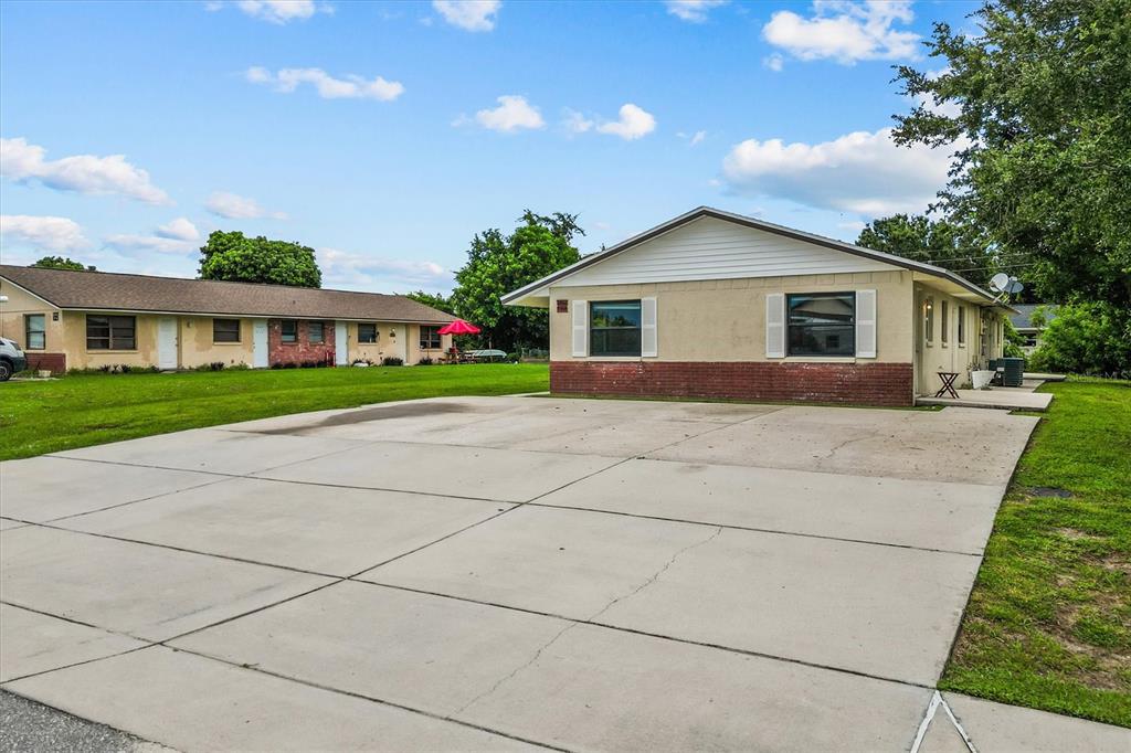 A single-story building with a concrete parking area and a large grassy lawn — 27242 SUNNYBROOK ROAD, PUNTA GORDA, FL