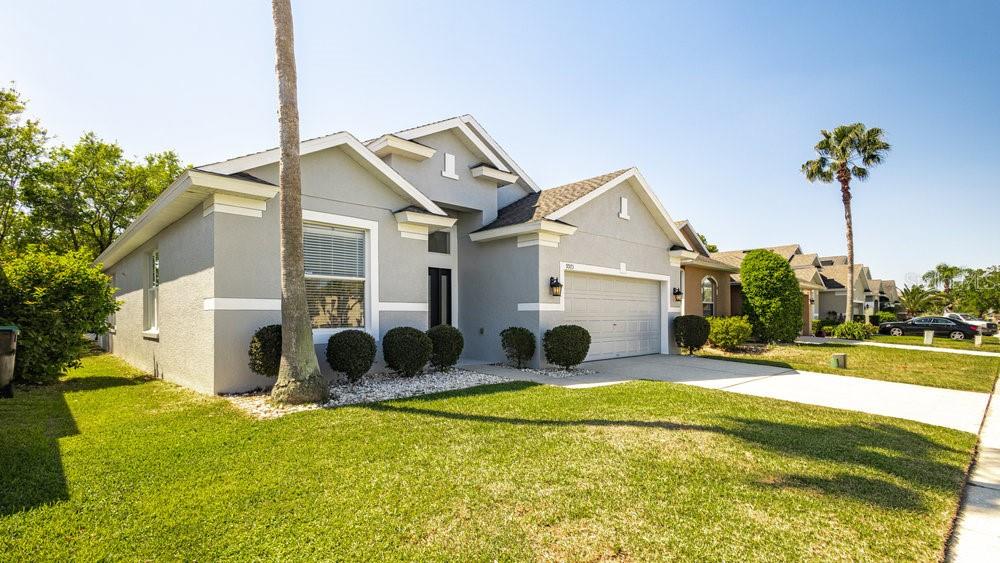 A single-story gray house with a two-car garage and a palm tree in the yard — 9973 CYPRESS KNEE CIRCLE, ORLANDO, FL