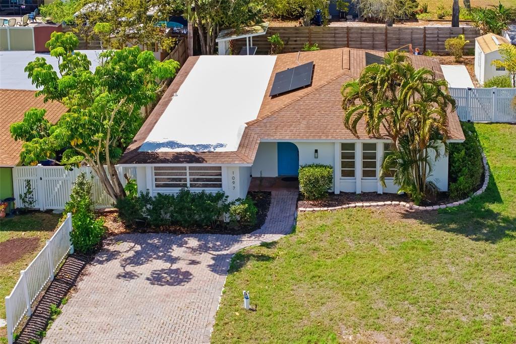 A single-story house with a brick paver walkway, blue front door, and palm trees — 1097 WILLIS AVENUE, SARASOTA, FL