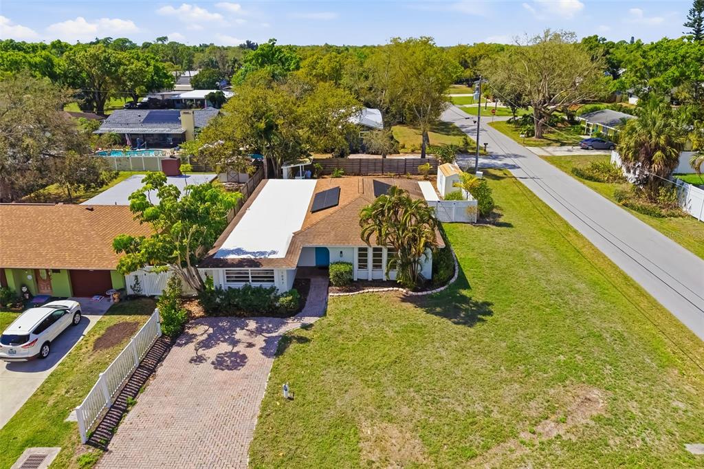 An aerial view of a single-story house with a white roof section and solar panels — 1097 WILLIS AVENUE, SARASOTA, FL