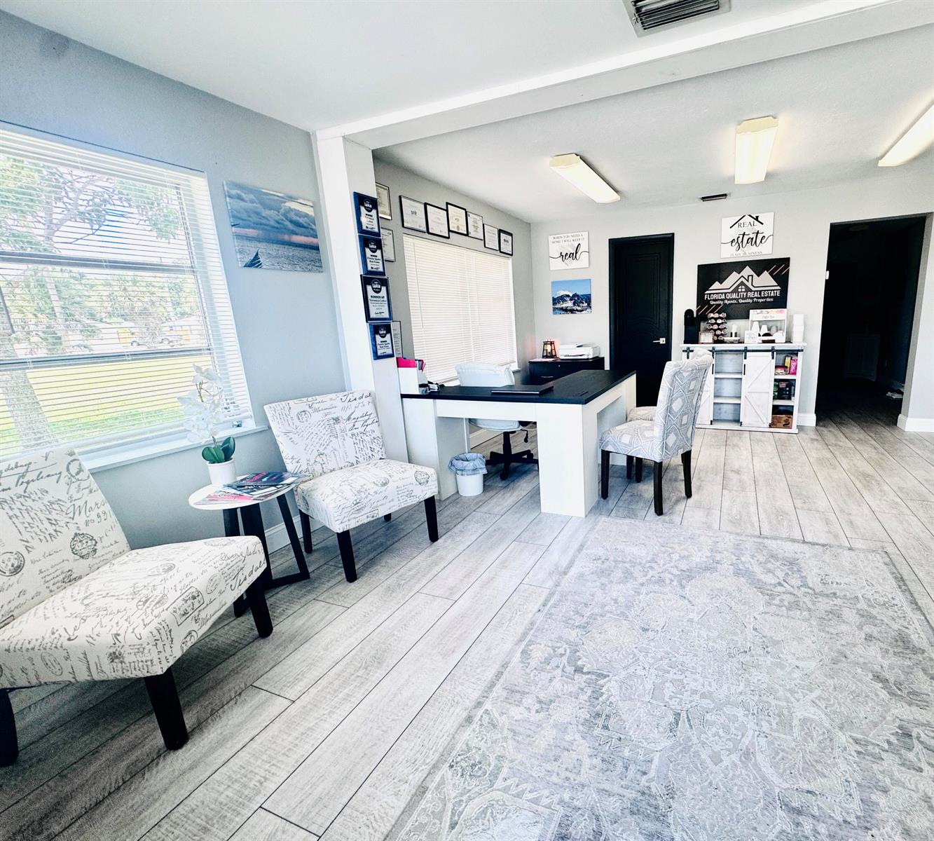 A modern office space features a desk, patterned chairs, light wood flooring, and wall decor — 206 SW 3rd Street, Okeechobee FL 34974, OKEECHOBEE, FL