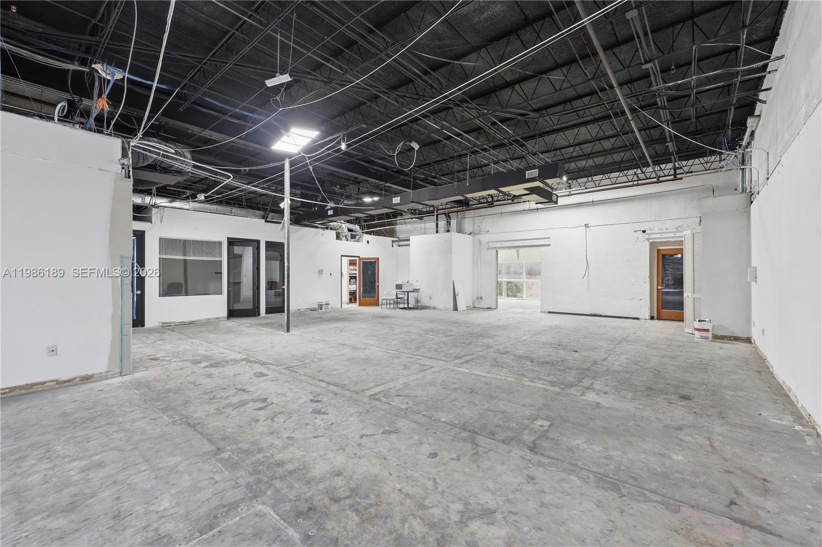 An empty commercial space features exposed black ceilings, concrete floors, and multiple interior doorways — 2950 N 28th Ter, Hollywood FL 33020, HOLLYWOOD, FL