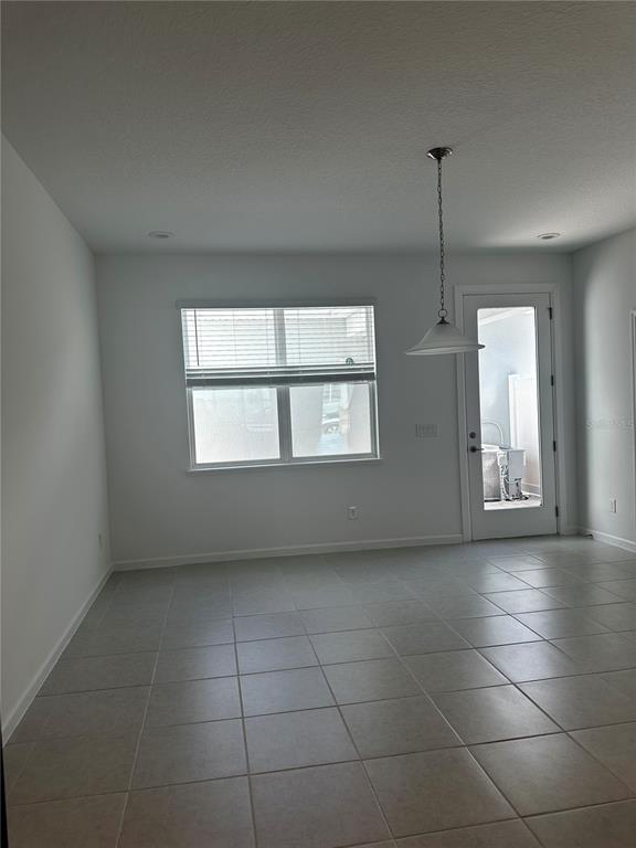 An empty room features light-colored tile flooring, a window with blinds, and a glass-paneled door — 14099 LOCHEND WAY, WINTER GARDEN, FL