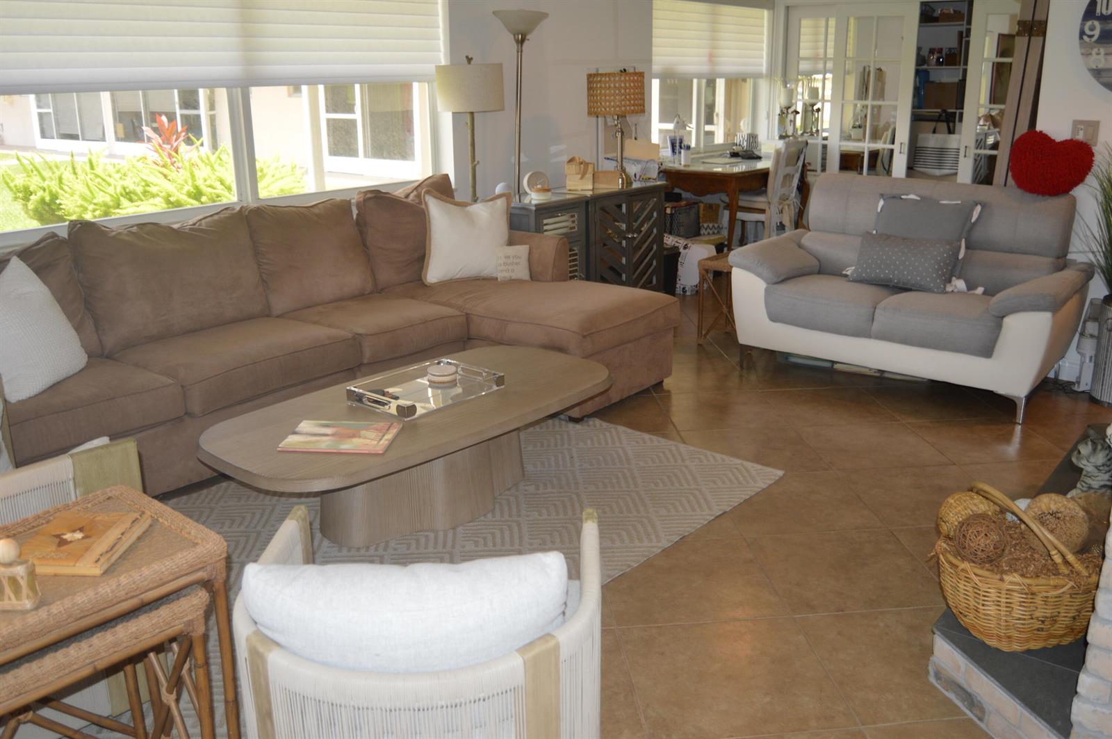 A living room features a brown sectional sofa, a grey loveseat, and a coffee table — 745 SE 19th Avenue # 114, Deerfield Beach FL 33441, DEERFIELD BEACH, FL