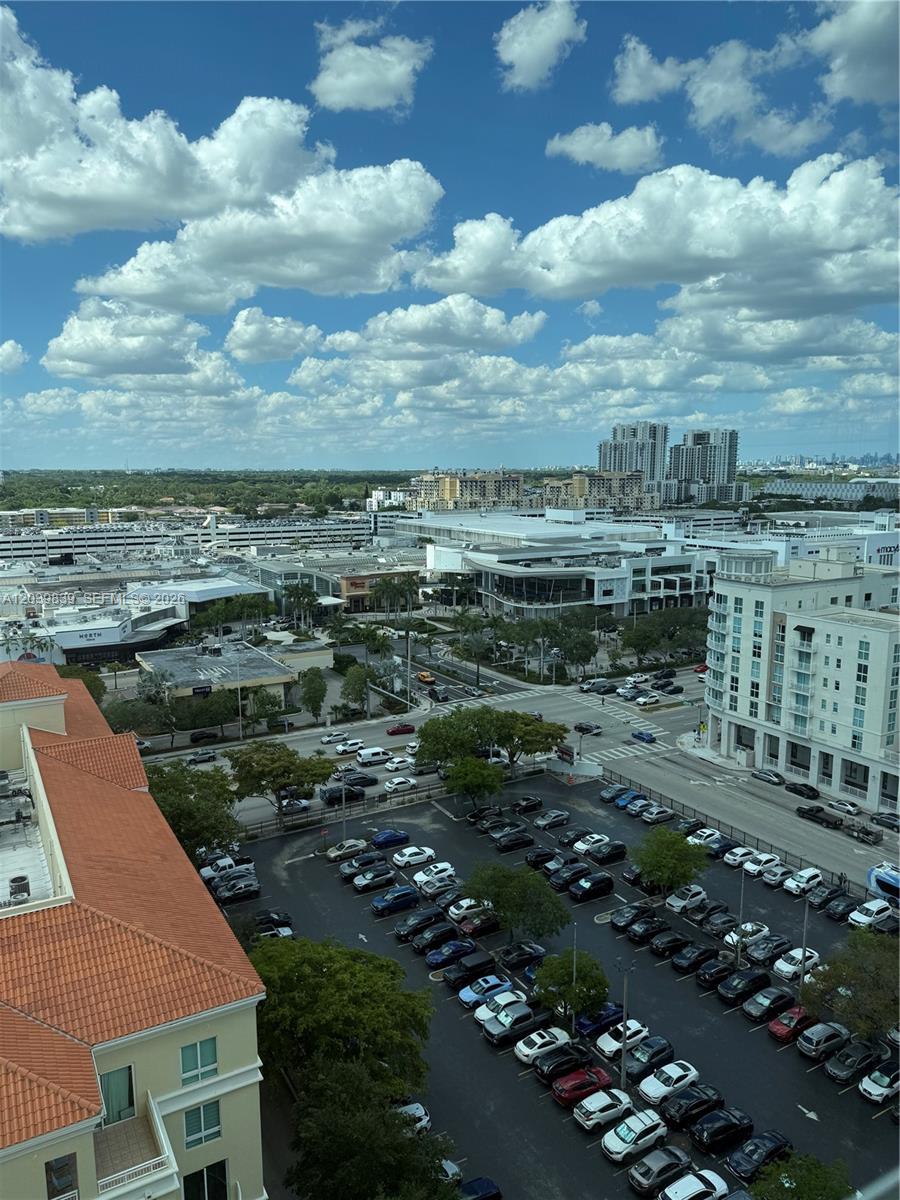 An elevated view shows a parking lot, surrounding commercial buildings, and a distant city skyline — 7350 SW 89th St # 1602S, Miami FL 33156, MIAMI, FL