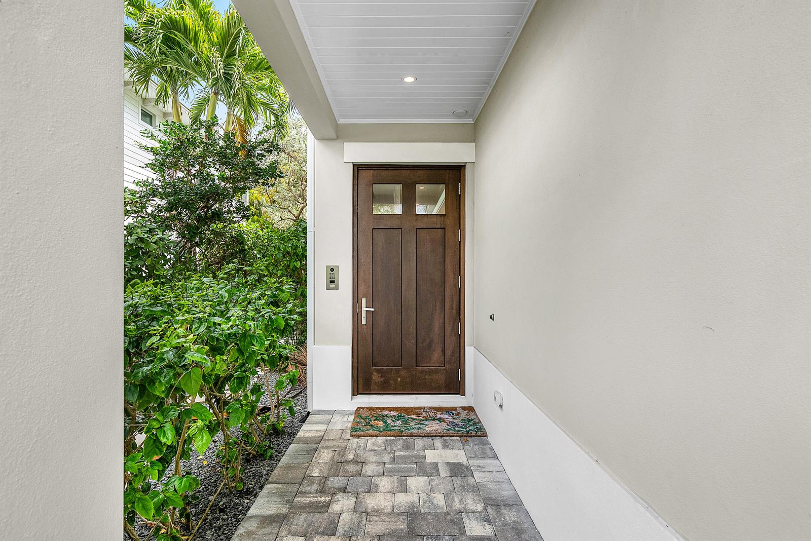 A wooden front door with glass panels is set in a covered entryway with pavers — 436 NE Wavecrest Way, Boca Raton FL 33432, BOCA RATON, FL