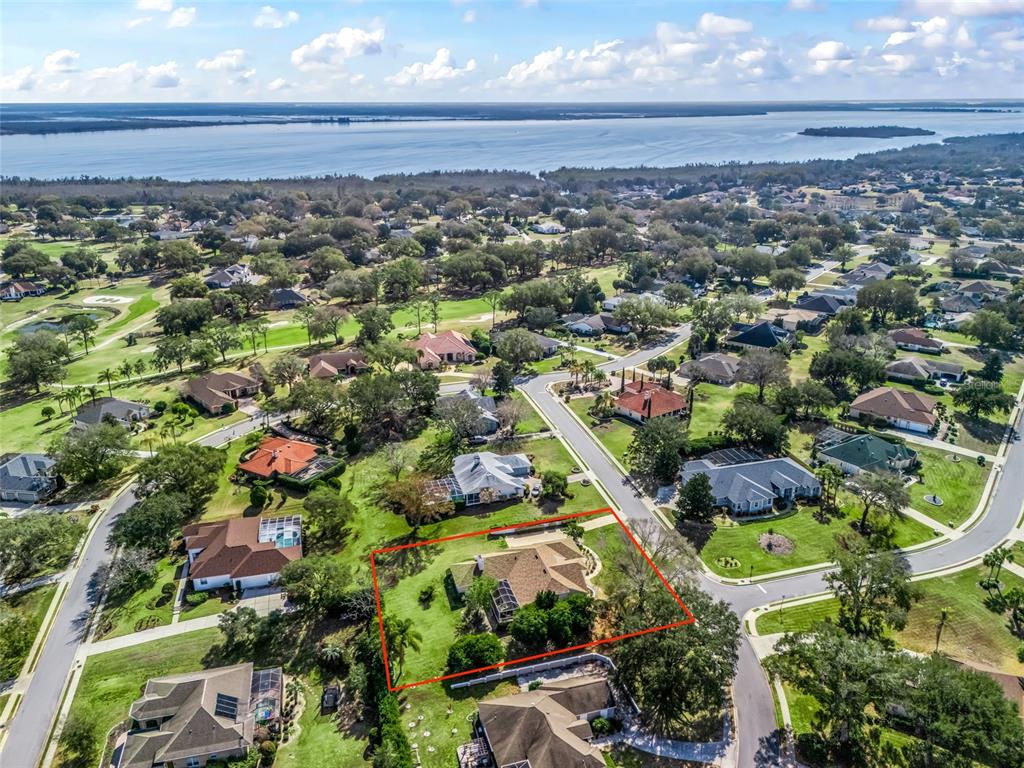 An aerial view shows a single-story house with a pool enclosure on a landscaped lot — 5321 GREENS DRIVE, LADY LAKE, FL