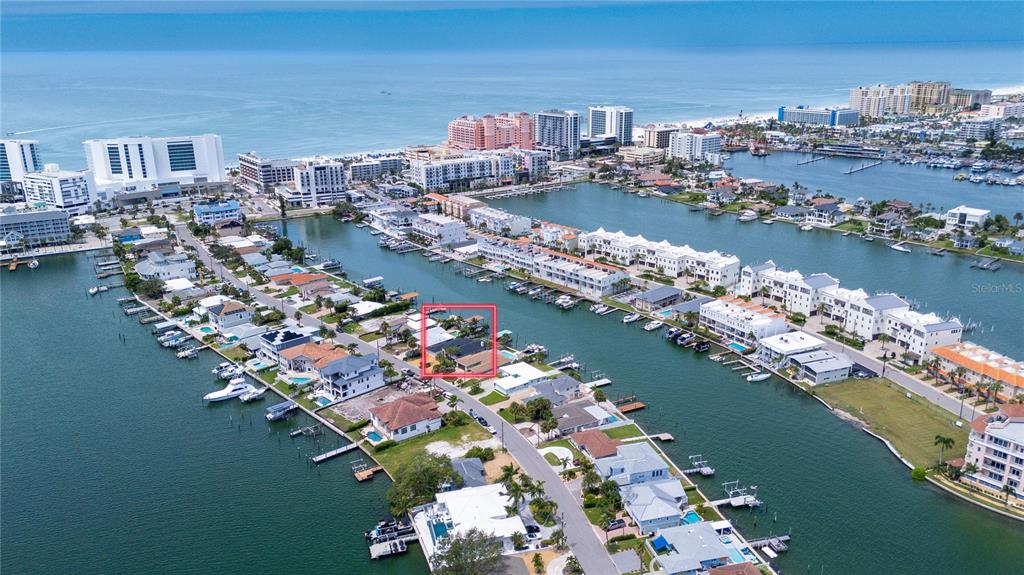 An aerial view shows a waterfront residential property highlighted by a red box — 166 BAYSIDE DRIVE, CLEARWATER BEACH, FL