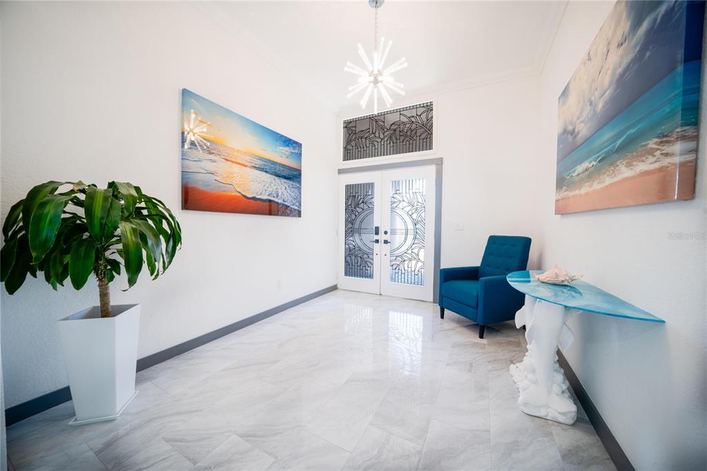 A white kitchen wet bar with a wine cooler sits between a hallway and entryway — 166 BAYSIDE DRIVE, CLEARWATER BEACH, FL