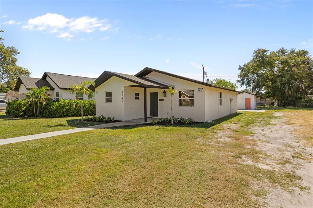 An aerial view shows two houses with gray roofs, a wooden deck, and a grassy yard — 2722 14TH AVENUE S, ST PETERSBURG, FL