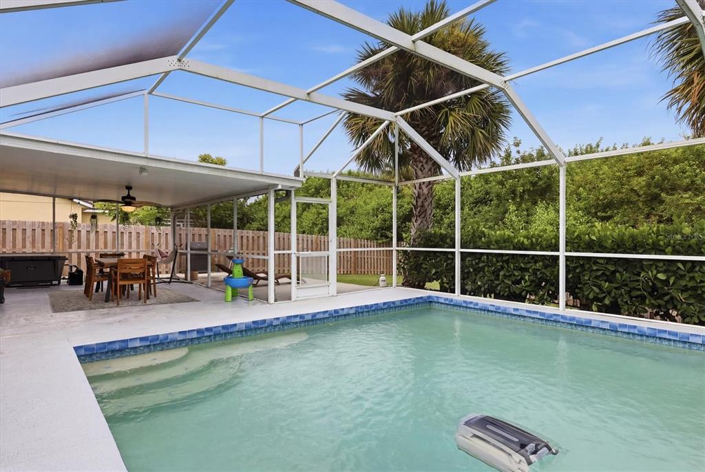 A swimming pool with a screen enclosure and a covered patio area with outdoor furniture — 306 111TH STREET E, BRADENTON, FL