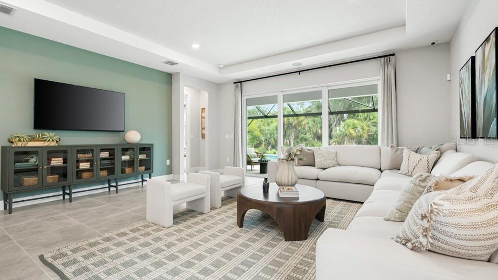 A living room features a green accent wall, a large sectional sofa, and sliding glass doors — 12751 DOCKYARD TRAIL, PALMETTO, FL
