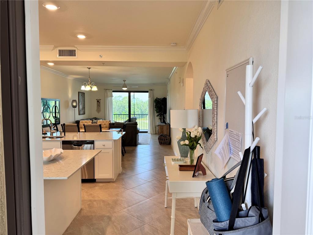 An open-concept kitchen and living area with tile floors and a view of the balcony — 17724 GAWTHROP DRIVE UNIT 304, BRADENTON, FL