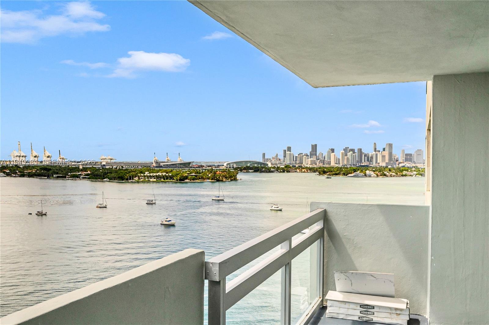 A balcony overlooks a bay with boats and a distant city skyline under a blue sky — 1500 Bay Rd # 1536S, Miami Beach FL 33139, MIAMI BEACH, FL