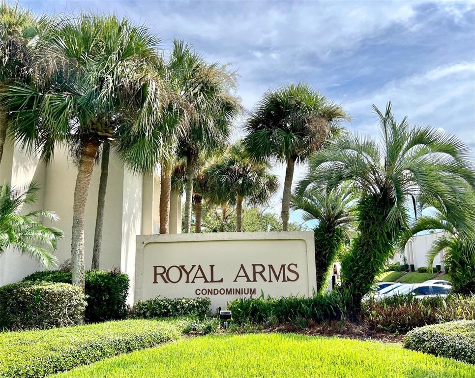 A sign for Royal Arms Condominium stands in front of palm trees and a building — 506 ORANGE DRIVE UNIT 15, ALTAMONTE SPRINGS, FL