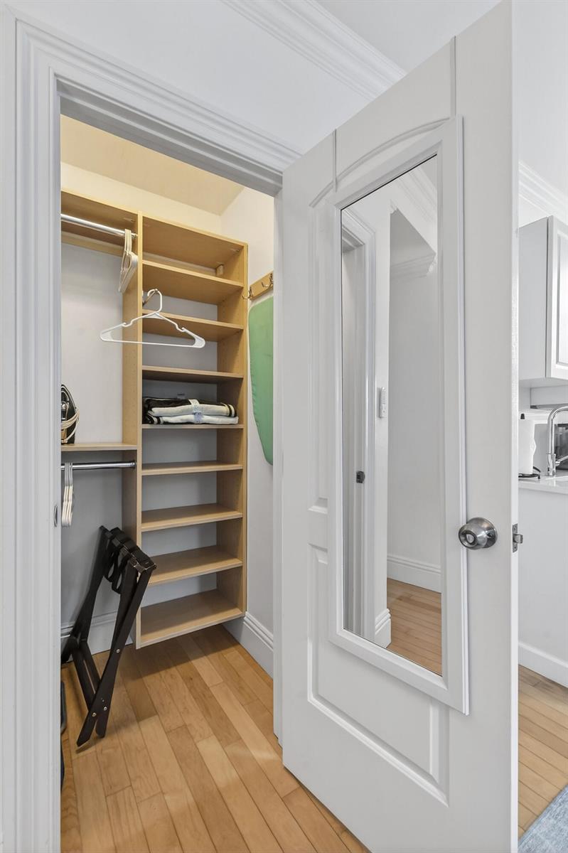 A closet with wooden shelving and a hanging rod sits behind a mirrored door — 235 Sunrise Avenue # 3265, Palm Beach FL 33480, PALM BEACH, FL