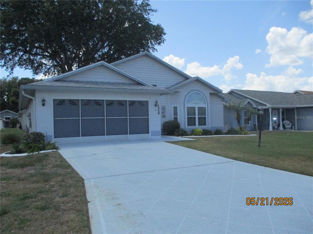 A single-story house with a screened garage door and a concrete driveway — 6228 EGRET DRIVE, LAKELAND, FL